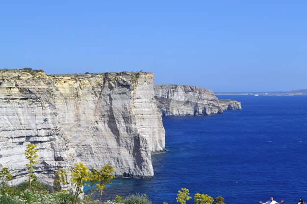 A cliff face in the sea with the sea in the background