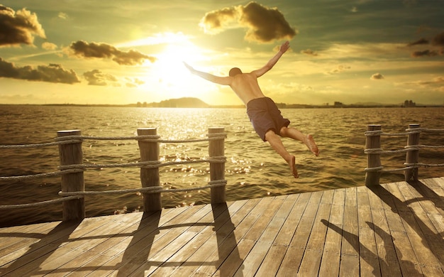 Cliff jumping into the ocean at sunset summer fun\
lifestyle