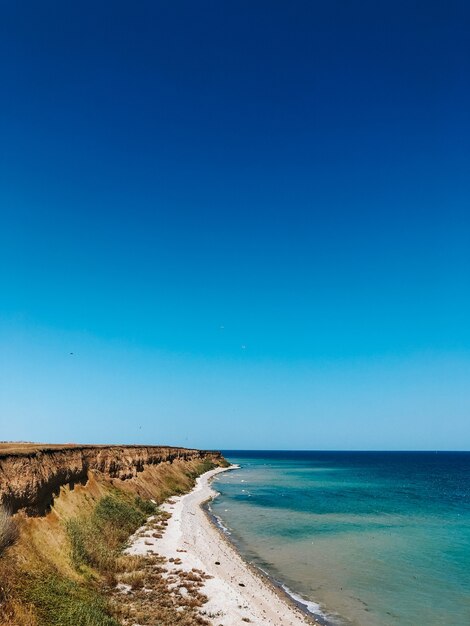 cliff sea blue aquamarine waves line sunny beach. soft wave of ocean foam. 