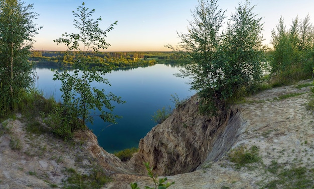 Cliff on the shore of the quarry in the evening