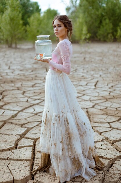 Climate change and global warming concept girl with water saves fish