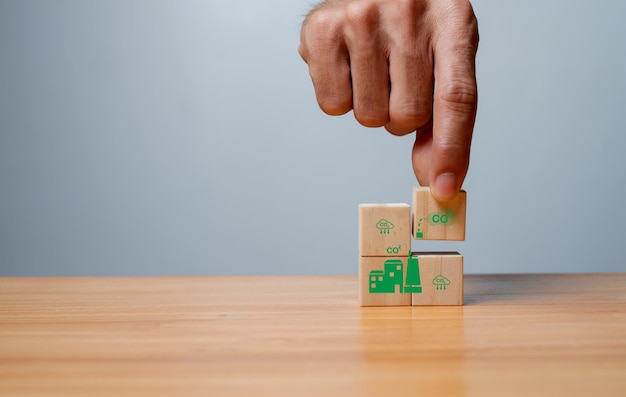 Climate neutral long term strategy Hand put wooden cubes with decrease carbon emission icon and green iconLow carboncarbon neutral concept Green banner