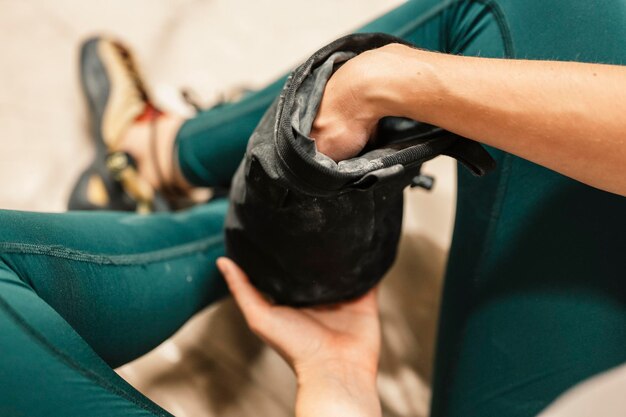 Climber wearing in climbing equipment Practicing rockclimbing on a rock wall indoors Xtreme sports and bouldering concept