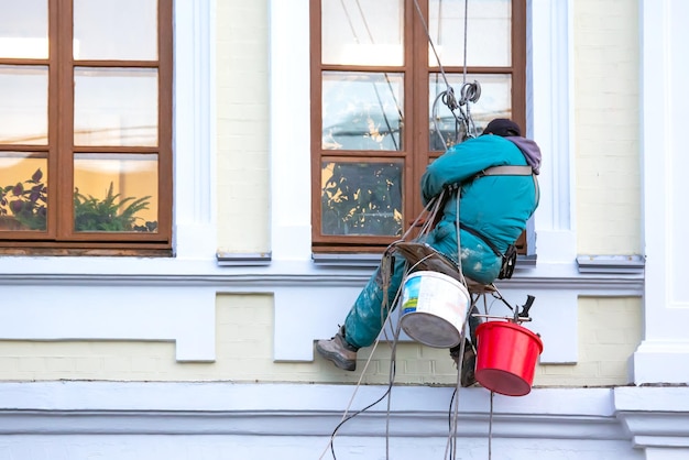 Climber worker cleaning of windows and the facade of a\
renovated residential building construction business industry