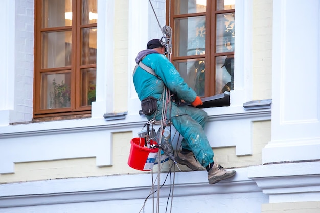 Climber worker cleaning of windows and the facade of a\
renovated residential building construction business industry