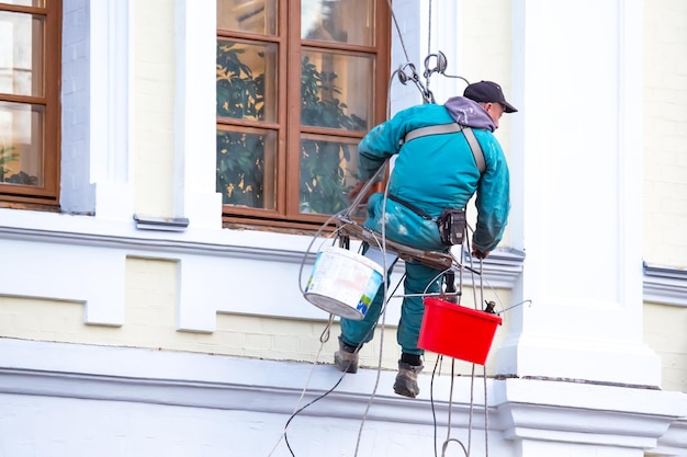 Climber worker cleaning of windows and the facade of a renovated residential building construction business industry