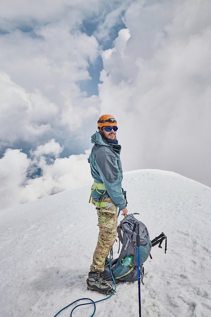 クライミング カズベキスタン ジョージアの男性登山家が頂上に立っている コーカサス山脈の自然 カズベキスタンのアルピニスト遠征