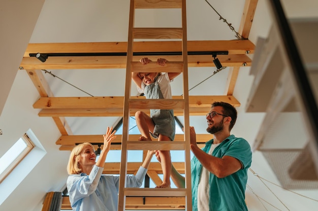 Climbing little girl with parents help