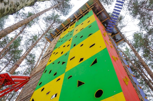 A climbing wall tower made of wood in the forest.