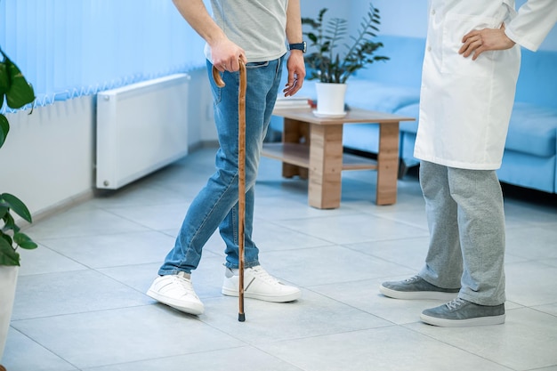 At the clinic Patient with a stick walking to the doctor