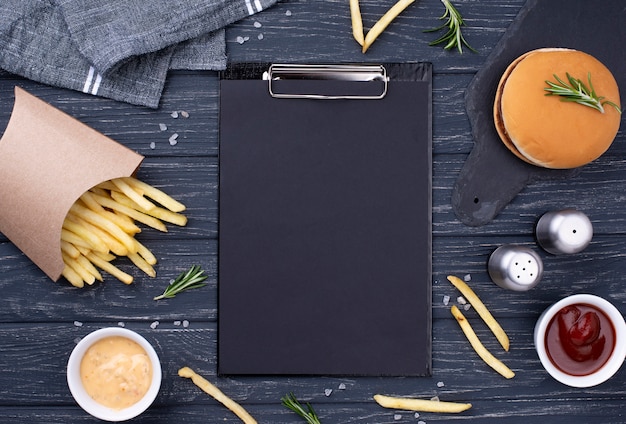 Foto appunti accanto a deliziosi hamburger con patatine fritte