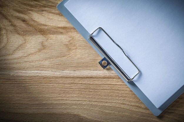 Clipboard blank sheets of paper on wooden board