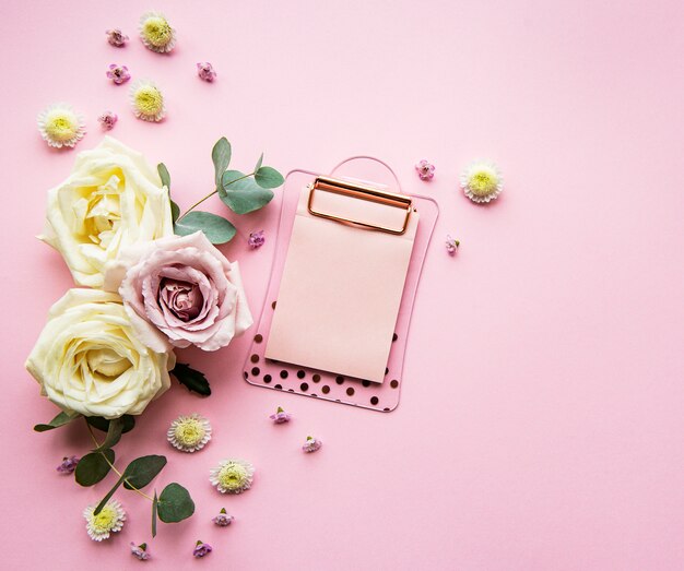 Clipboard and flowers top view