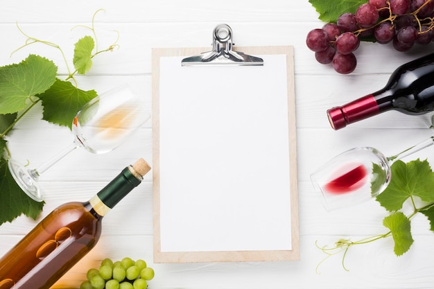 Foto mock-up di clipboard circondato da bottiglie di vino