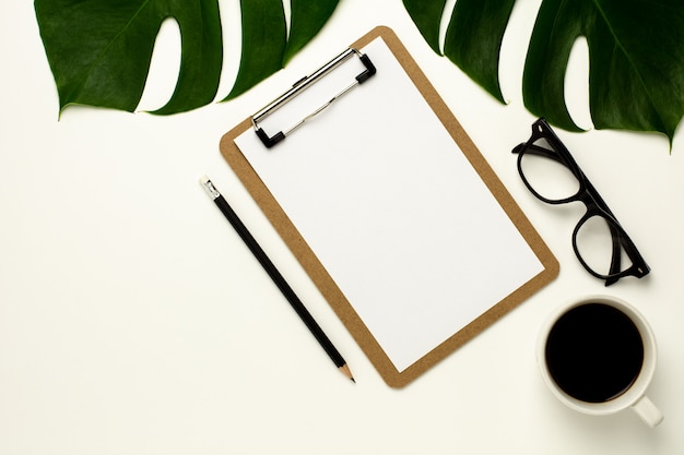 Clipboard and white paper on white office desk background