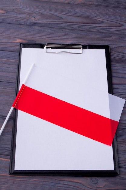 Clipboard with blank paper and bicolored flag of poland