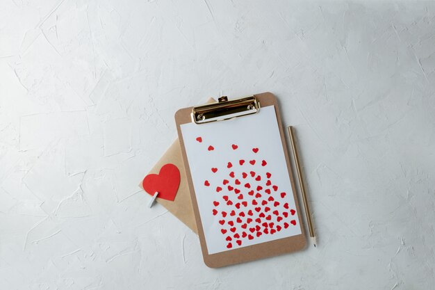 Clipboard with blank paper, red paper hearts