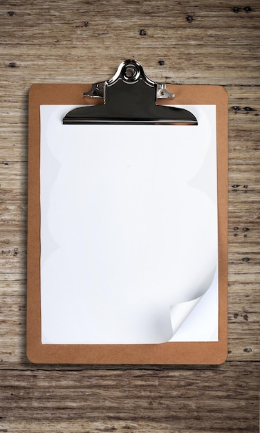 Photo clipboard with a blank sheet of paper on wooden table