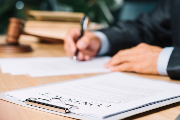 Photo clipboard with contract papers over wooden desk in courtroom