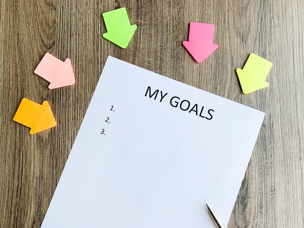 Clipboard with my goals on wood desk.