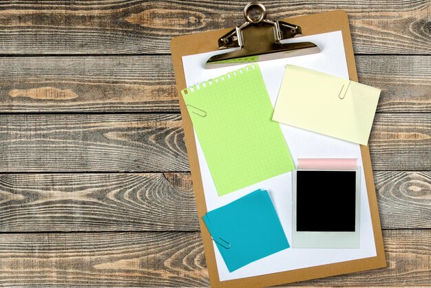 Photo clipboard with notes and photo on wooden background