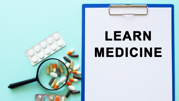 A clipboard with paper lies on a table near drugs and a syringe