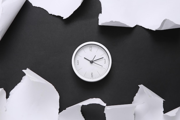 Photo clock on black background with white torn paper concept art minimalism top view