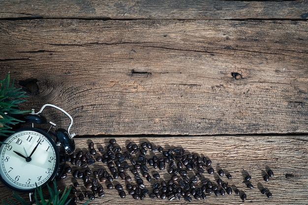 A clock and coffee beans on the desk top view