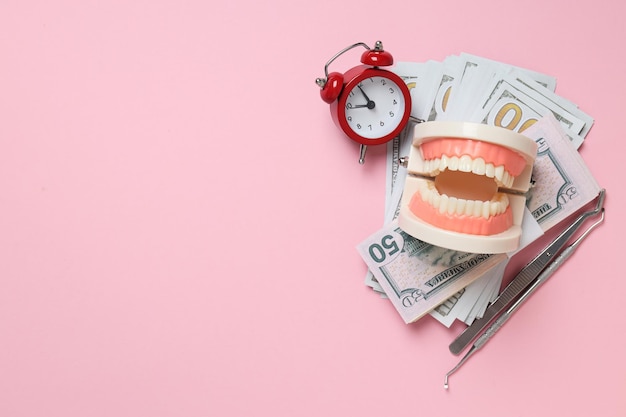 Clock decorative jaw and money on pink background space for text