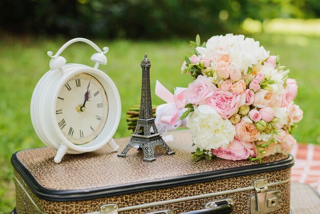 Clock, Eiffel Tower and bouquet on a retro suitcase