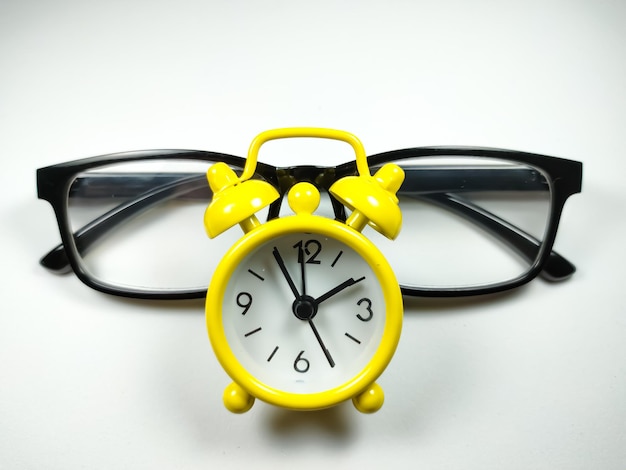 Clock and glasses on white background