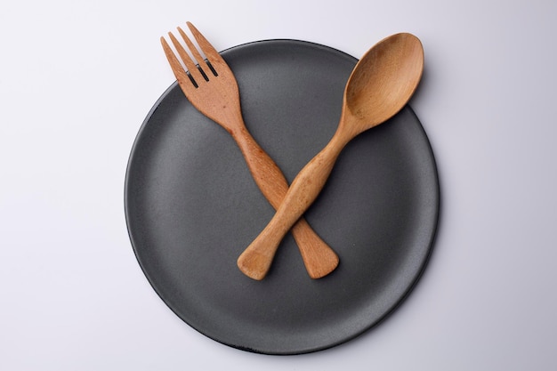 Clock grey plate with wooden spoon and fork eating time meal concept