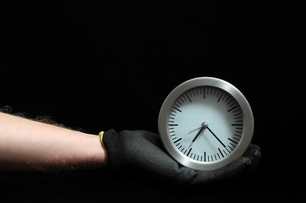 Photo clock and an hand on a black background