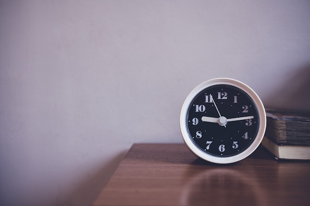 The clock is on table in bedroom