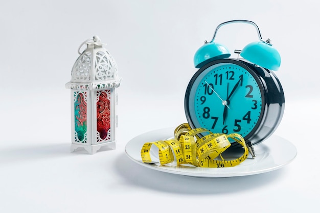 Photo clock and measuring tape on the plate with an arabic lamp fasting concept