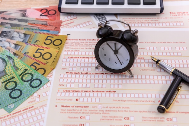 Clock and pen on australian tax form close up