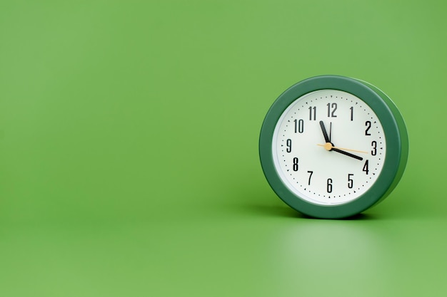 Clock precious time alarm clock on green background concept of time working with time