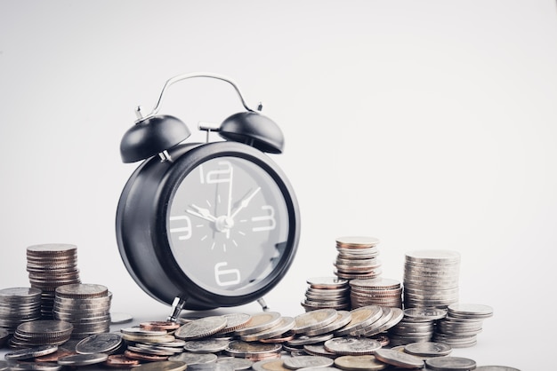 Photo clock and rows of coins for time of finance and business concept