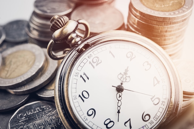 clock and rows of coins for time of finance and business concept