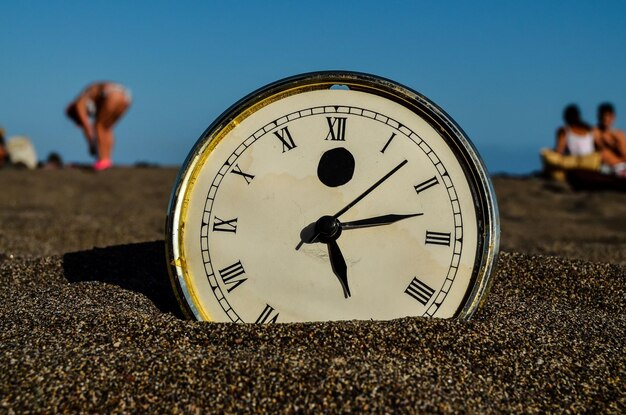 Foto orologio sulla spiaggia di sabbia