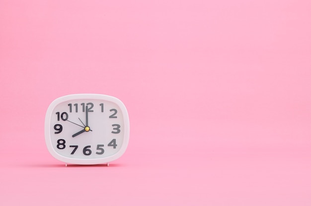 Часы, показывающие время на розовом фоне