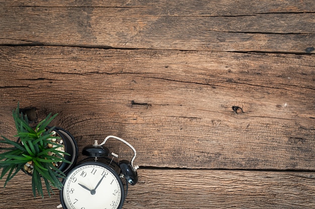 Clock and a tree on a wooden table top view