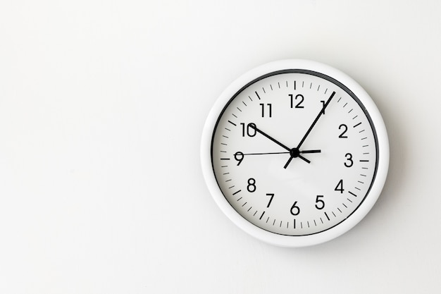 Photo clock, white arrow clock on white background woman's hand holding a round clock with black arrows, control, timing, time management, time, come, late, losing minutes, second