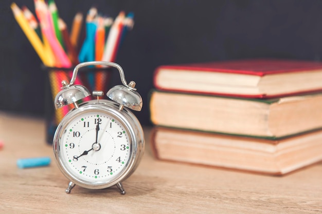 Clock with books and pencils