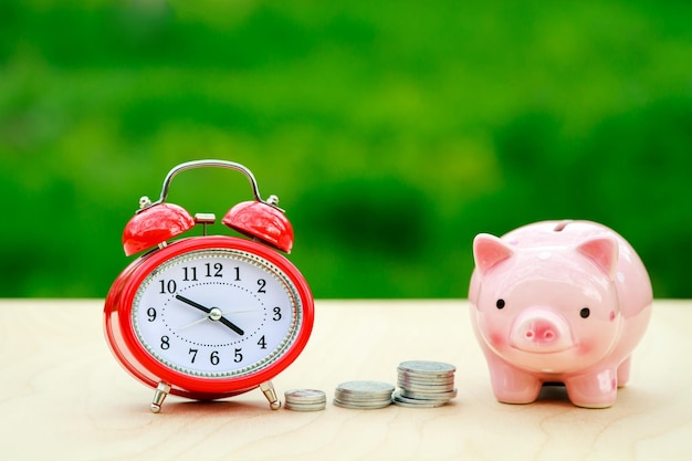 Clock with coins and piggy bank