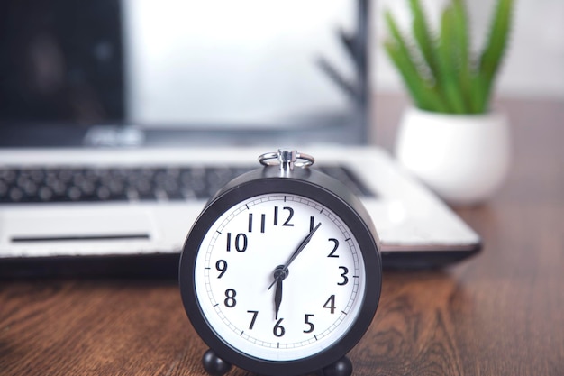 Clock with computer on the table