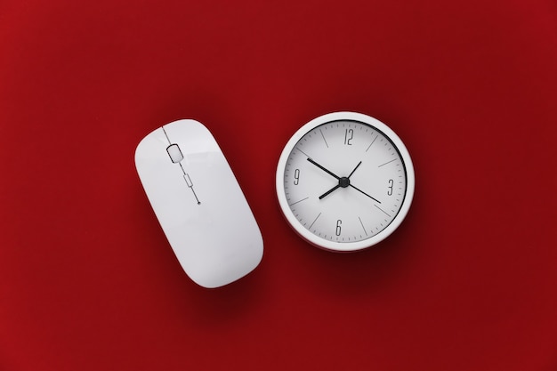 Clock with pc mouse on red background. Working Deadline. Top view.