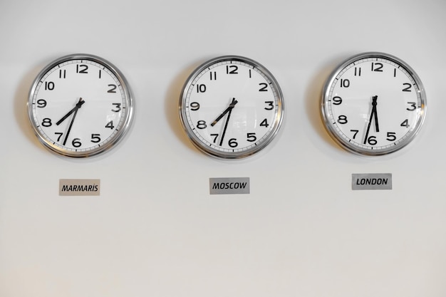 Photo clocks showing time in different cities on wall in hotel