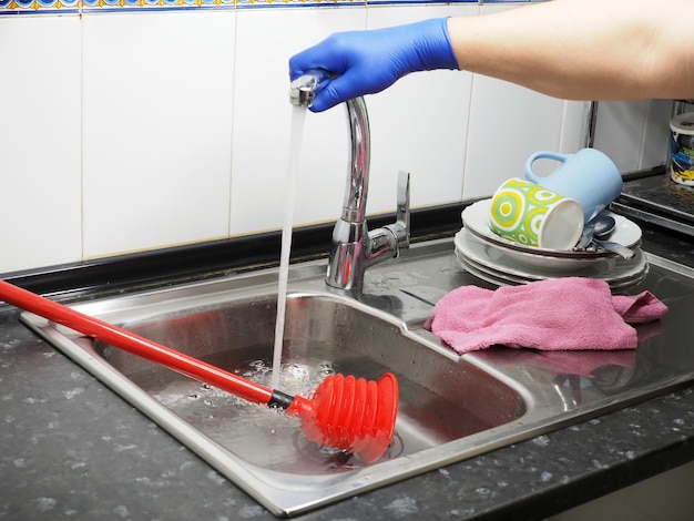 Clogged pipes and sewer drains in the kitchen The man turns off the water