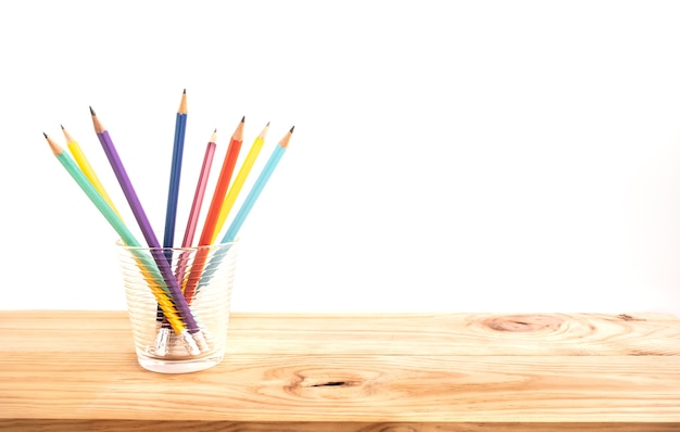 Clorful pencil in glass on wood bar table background